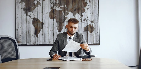 Mężczyzna analizujący dokumenty podczas pracy biurowej